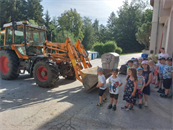eine Gruppe von Kindern, die vor einem Traktor stehen
