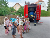 eine Gruppe von Kindern, die vor einem Feuerwehrauto stehen